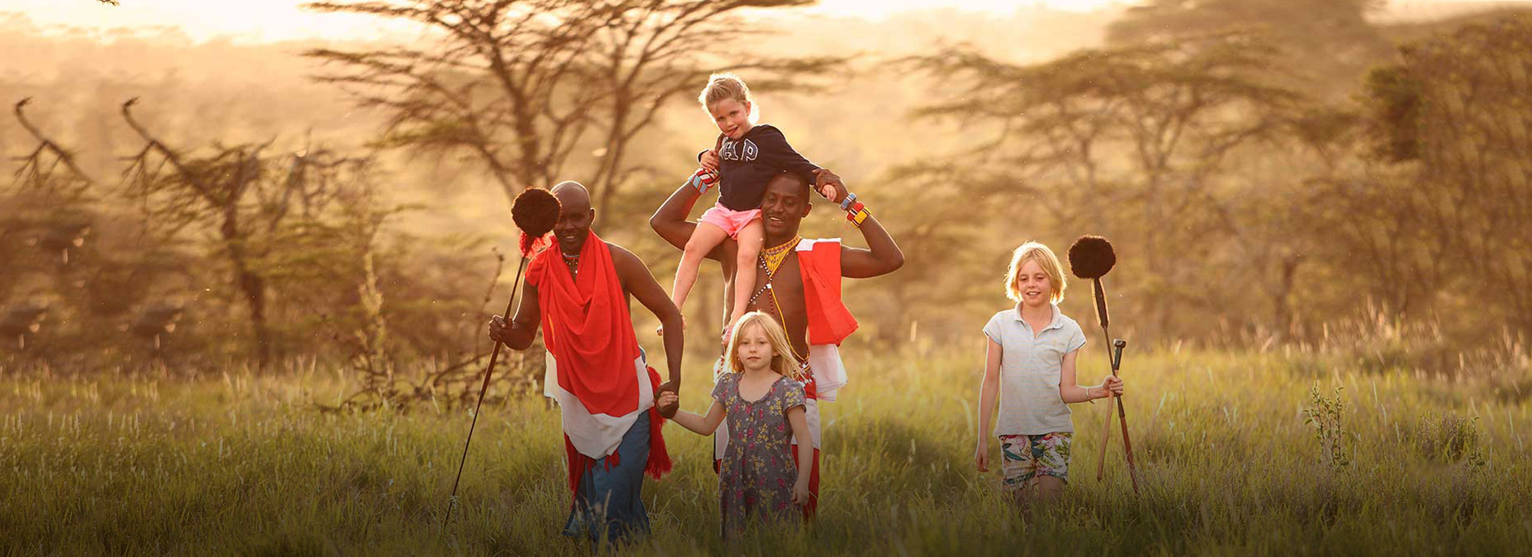 three tourists children walking with two masai locals through the bush an amazing learning life experience on a beautiful holiday in Africa