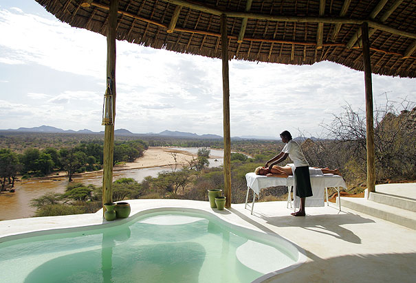 spa on a luxury safari in samburu masseur massages woman on pool deck river bank