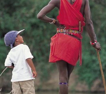 maasai warrior looks down to talk to small boy ®bushtreksafaris